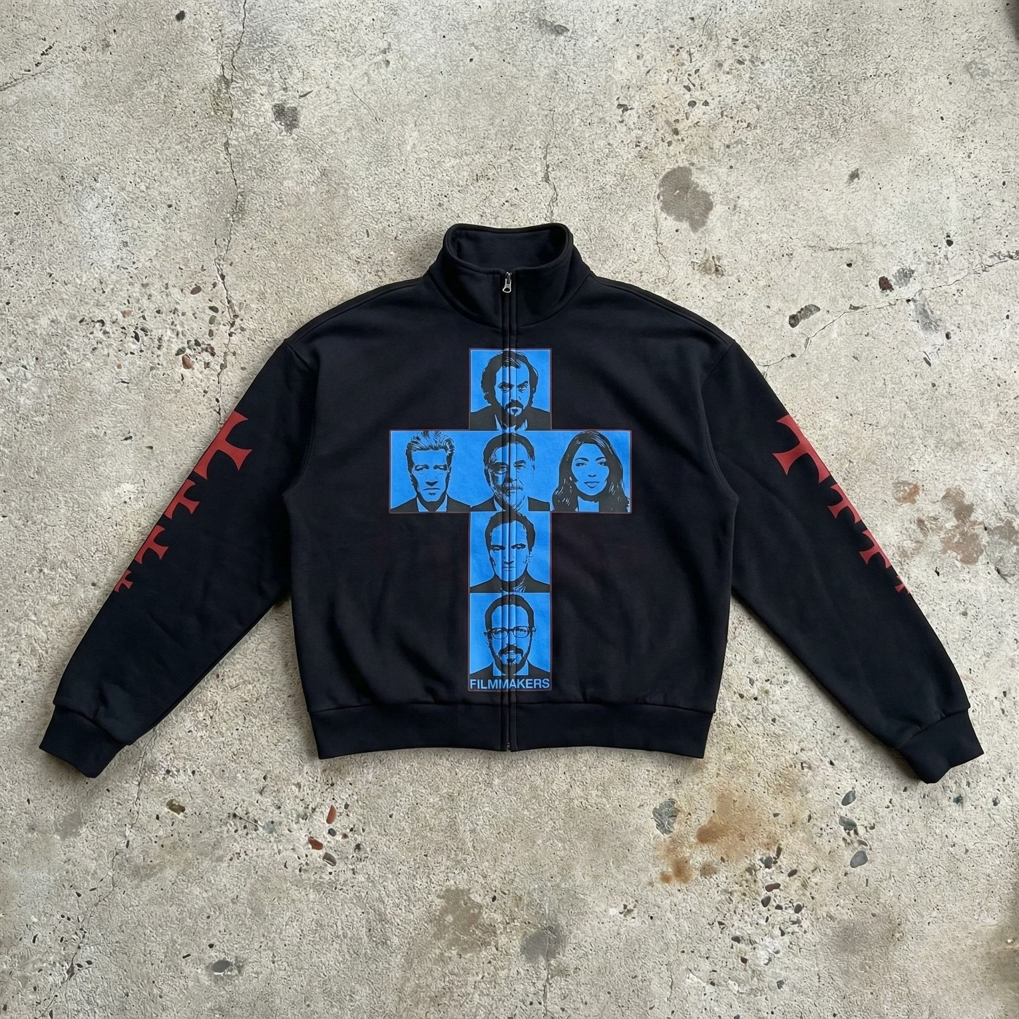 Black jacket with blue graphic design on a concrete surface